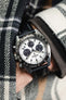 Black Artem Classic Sailcloth Strap with grey stitching fitted to panda and silver seiko prospex speedtimer with chronograph on wrist in pocket of check flannel shirt. 