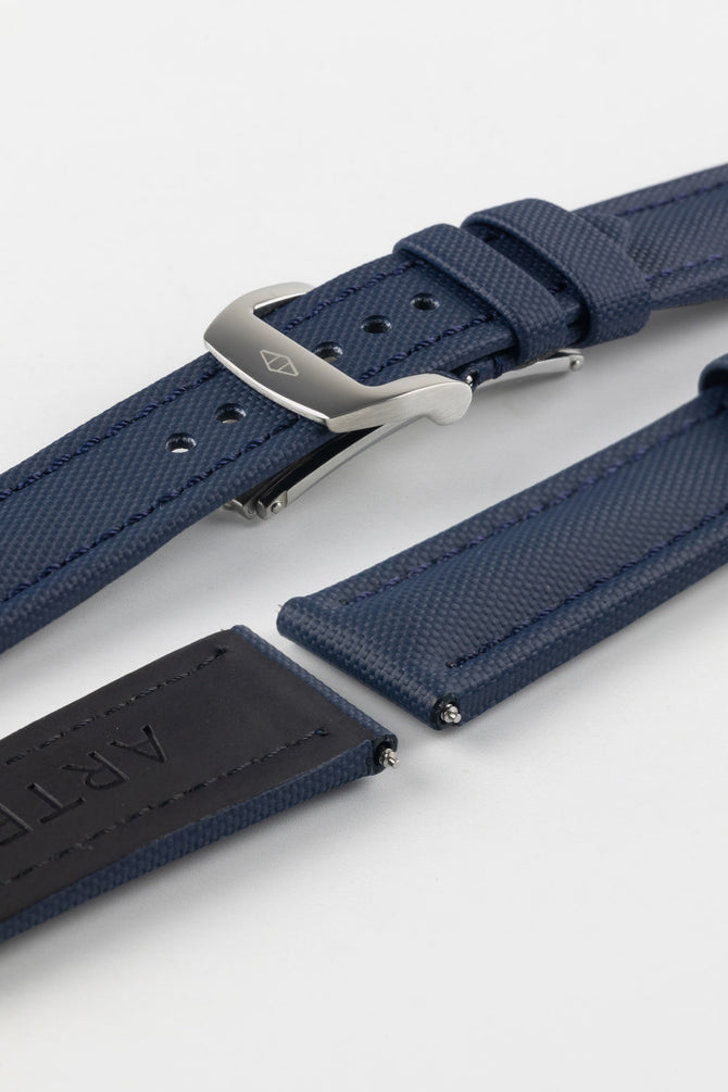 Polished stainless steel RM style deployment clasp with Artem Straps logo embossed on Artem Straps Navy Blue Classic Sailcloth watch strap and top and bottom of Lug end showing rubber coated underside.