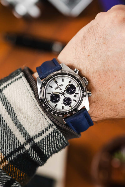 Navy Blue Artem Straps classic sailcloth watch strap fitted to black and white Panda Seiko chronograph speedtimer timepiece on wrist with white flanel shirt. 