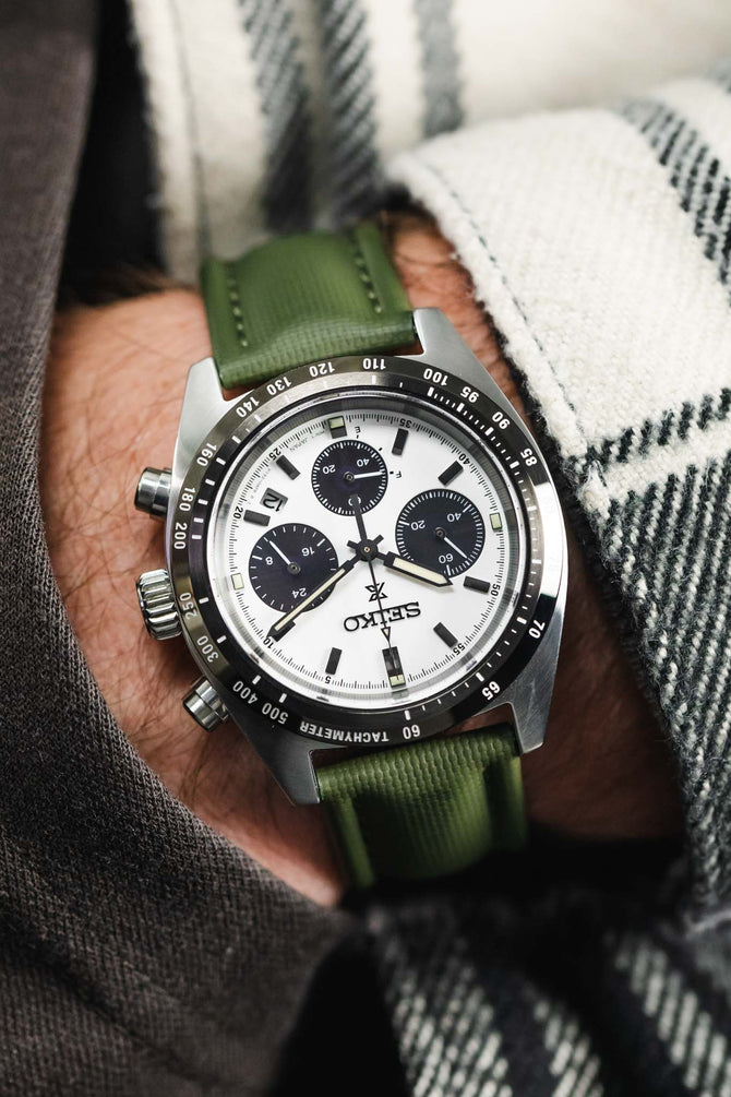 White and Black Panda Seiko Speedtimer with chronograph fitted to Green Artem Straps classic sailcloth watch strap in pocket of grey trousers.