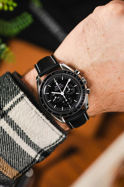 Artem Straps Loop-Less Sailcoth Watch Strap in Black with White stitching fitted to  Black Omega Speedmaster Moonwatch worn on wrist with white and black flannel shirt