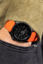 Seiko 5 sports blackout SRPD79K1 fitted with orange bonetto cinturini rubber watch strap worn on wrist with hand in pocket