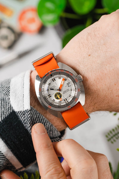 Doxa sub 300 searambler silver lung limited edition fitted with orange bonetto cinturini 328 premium rubber one piece watch strap on wrist with flannel shirt