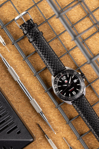 Tag Heuer Formula 1 black dial fitted with Di-Modell Carbonio Carbon-Embossed Leather Watch Strap in Black with logo embossed stainless steel buckle layed flat 