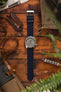 Seiko 5 Sports SRPG61K1 cement dial with Bonetto Cinturini 270 Navy Blue on Wooden Table