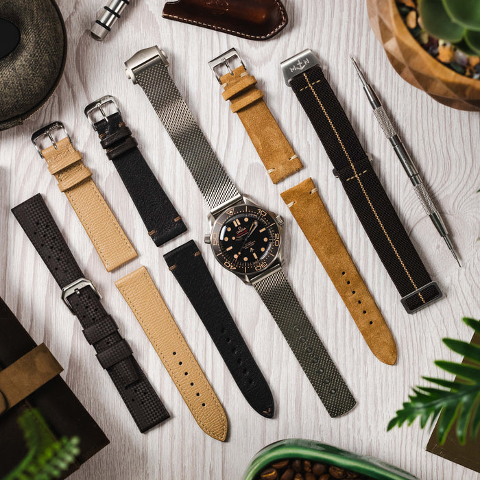 An Omega Seamaster NTTD lay with 5 strap pairings