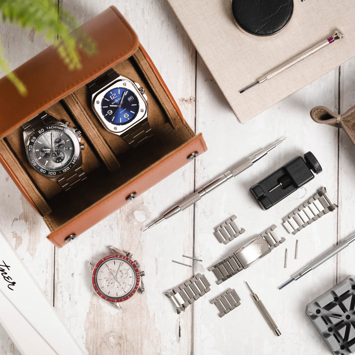 A TAG Heuer and Bell and Ross watch in a watch case with an omega speedmaster and a bracelet in pieces