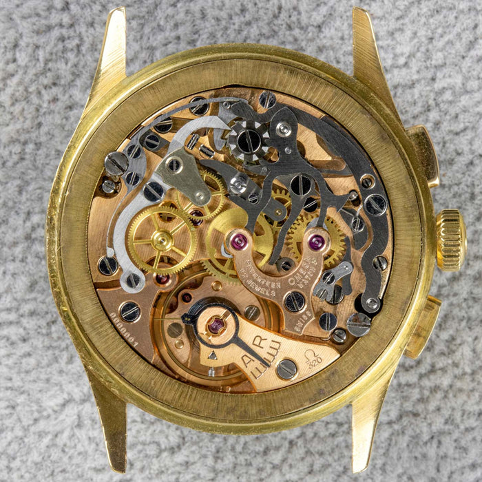 The internal mechanism of a vintage gold omega manual wind watch showing all components