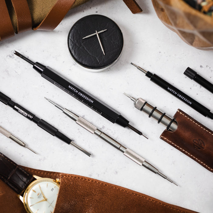 several different styles of watch spring bar tool lay together from different brands