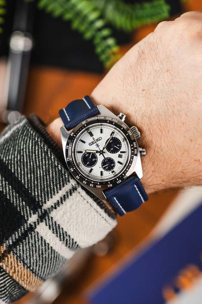 Navy Blue Artem Straps classic sailcloth watch strap with white stitching fitted to black and white Panda Seiko chronograph speedtimer timepiece on wrist with white flanel shirt
