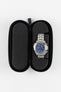 Open black hard-shell watch travel case with foam cushioning, showcasing a stainless steel chronograph watch secured within a protective padded insert.