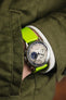 Lime Green Bonetto Cinturini 270 fitted to Studio Underd0g Go0fy Panda on wrist in pocket of green jacket
