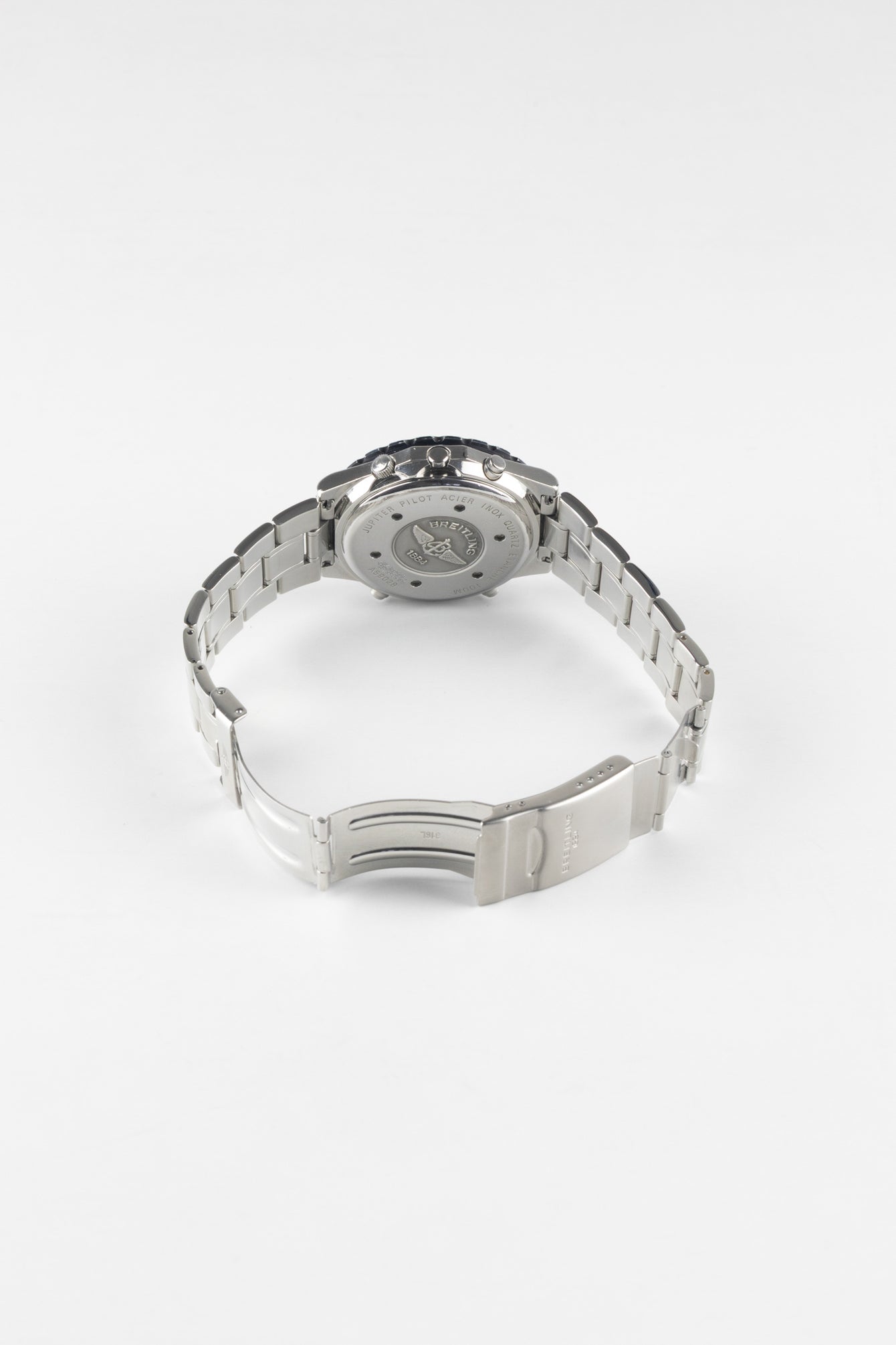 A view of the back of a Breitling Jupiter Pilot watch with the stainless steel bracelet and deployment clasp opened to show the interior engravings and case back.