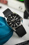 Seiko black dial dive watch leant against a Watch Obsession watch case with black Crafter Blue strap made from FKM Rubber