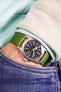 Pocket shot of a Hamilton khaki field in jeans pocket with turquoise hoodie and cream cord shirt, the watch is fitted to a green rubber strap