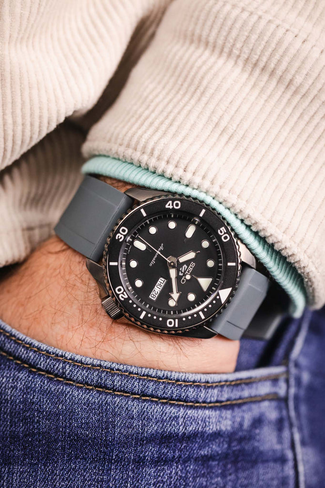 Pocket shot of a Seiko 5 Sports in jeans pocket with turquoise hoodie and cream cord shirt, the watch is fitted to a grey rubber strap