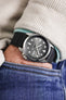 Pocket shot of a Seiko grey dial watch in jeans pocket with turquoise hoodie and cream cord shirt, the watch is fitted to a black rubber strap