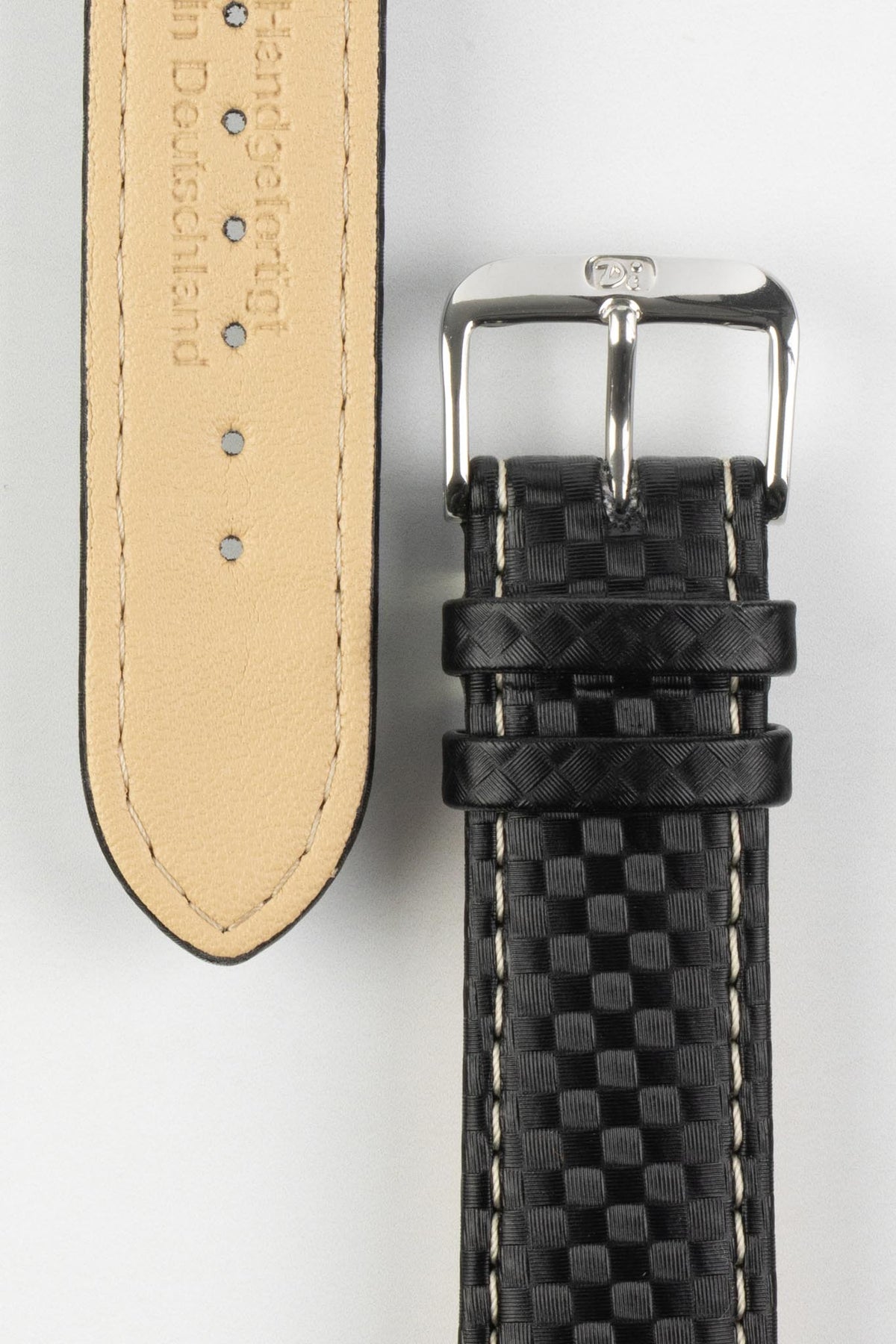 Black carbon-fibre-pattern leather watch strap with beige contrast stitching, German-made leather lining, and a polished stainless steel buckle, displayed on a white background.