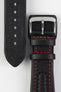Close-up detail view of a black padded leather rally-style watch strap featuring contrasting red stitching, integrated lug-end reinforcement panels, dual keeper loops, a polished stainless steel buckle, and a textured black leather lining with embossed branding, displayed on a light grey background to highlight the premium handcrafted construction, cushioned profile, and motorsport-inspired design.