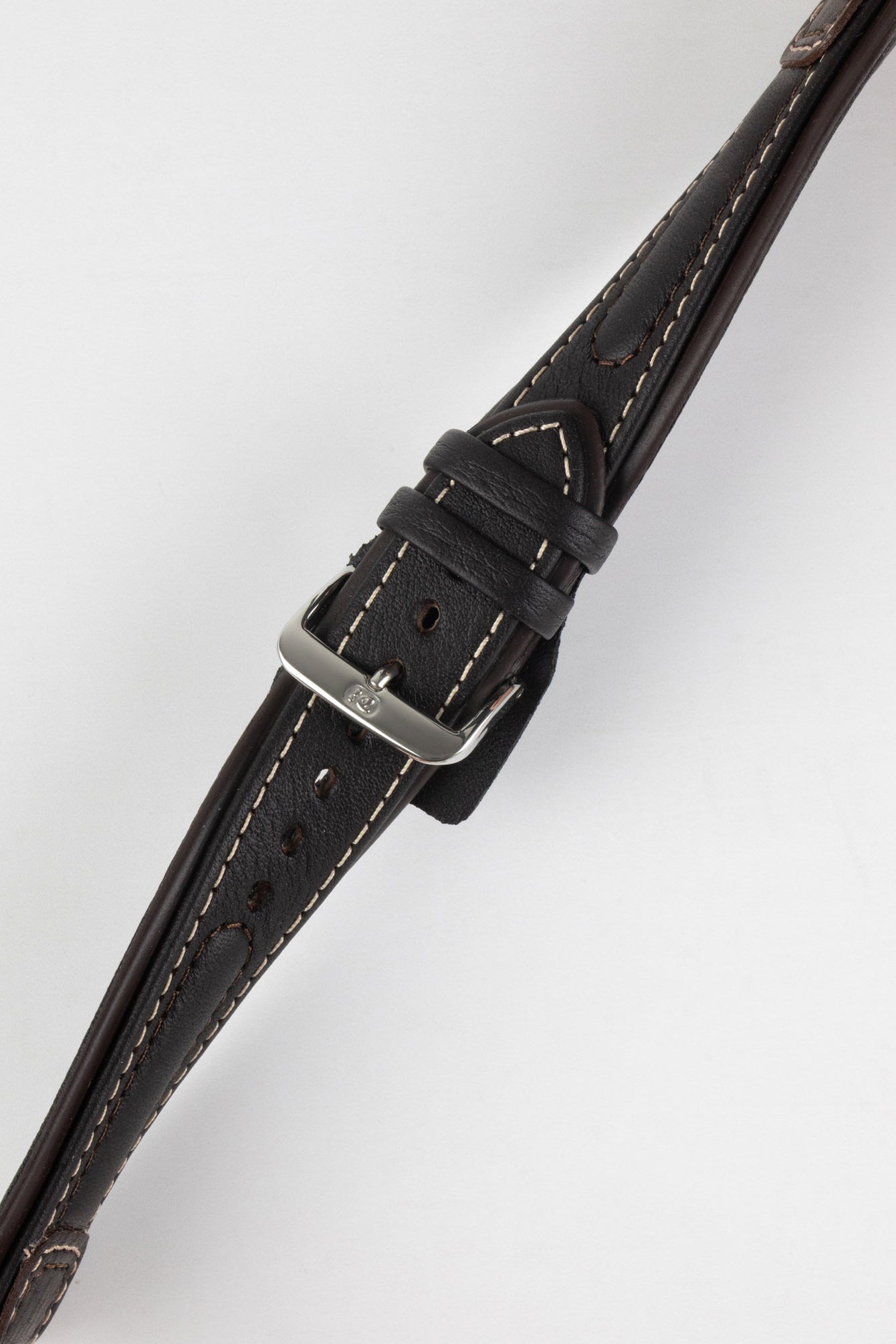Close-up of a dark brown padded leather rally-style watch strap with cream contrast stitching, dual keeper loops, multiple adjustment holes, and a polished stainless steel buckle, displayed diagonally on a light grey background to highlight the supple leather texture, tapered profile, cushioned construction, and vintage motorsport-inspired design.