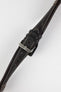 Close-up of a dark brown padded leather rally-style watch strap with cream contrast stitching, dual keeper loops, multiple adjustment holes, and a polished stainless steel buckle, displayed diagonally on a light grey background to highlight the supple leather texture, tapered profile, cushioned construction, and vintage motorsport-inspired design.