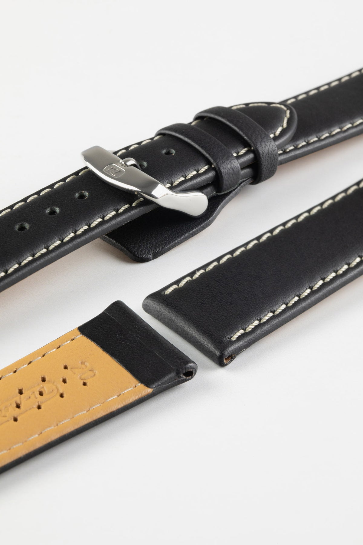 Black leather watch strap with beige contrast stitching, beige perforated leather lining, and a polished stainless steel buckle, displayed on a white background.
