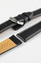 Black leather watch strap with beige contrast stitching, beige perforated leather lining, and a polished stainless steel buckle, displayed on a white background.