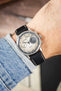 Studio Underd0g Bicompax chronograph watch on a black leather strap with beige contrast stitching, shown on wrist with a beige dial and stainless steel case.