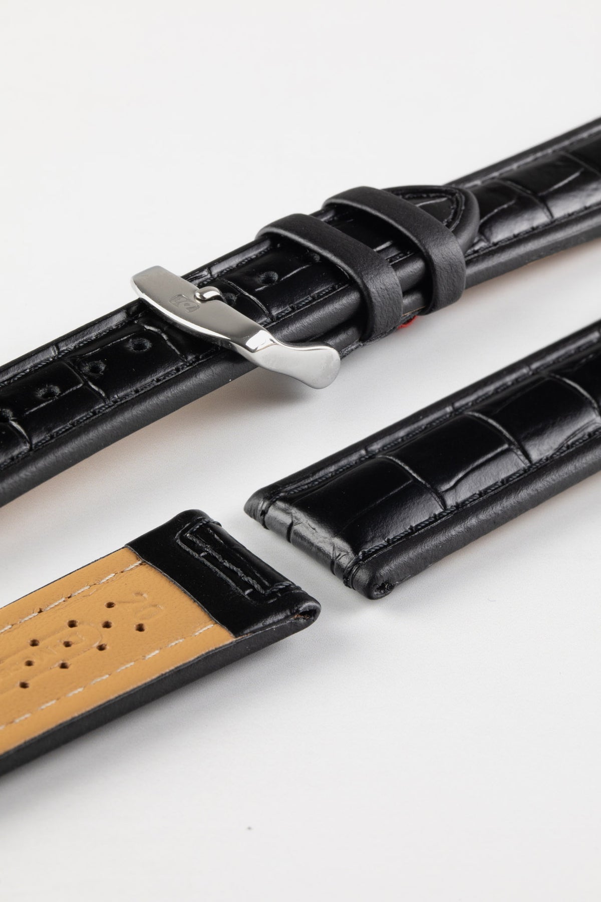 Black alligator-grain leather watch strap with matching black stitching, a polished stainless steel buckle, and crocodile-style embossed pattern, displayed on a white background.