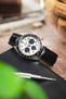 Seiko Speedtimer chronograph on a black alligator-grain leather strap, displayed on a leather pouch with watchmaking tools and vintage accessories.
