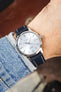 Seiko Presage automatic watch on a navy blue leather strap with cream contrast stitching, shown on wrist with a silver sunburst dial and stainless steel case.