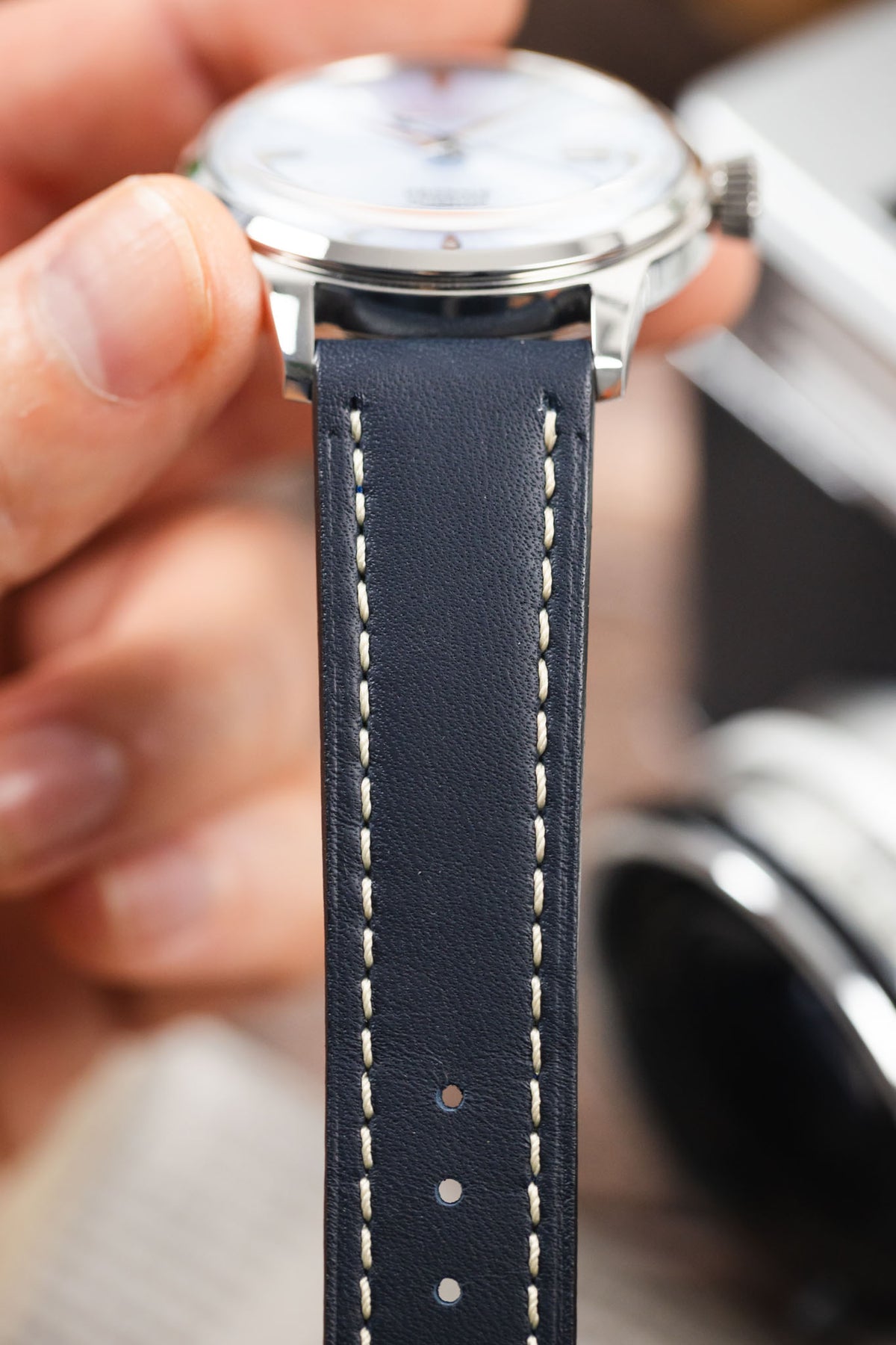 Navy blue leather watch strap fitted to a Seiko Presage automatic watch, highlighting the cream contrast stitching and smooth leather finish.