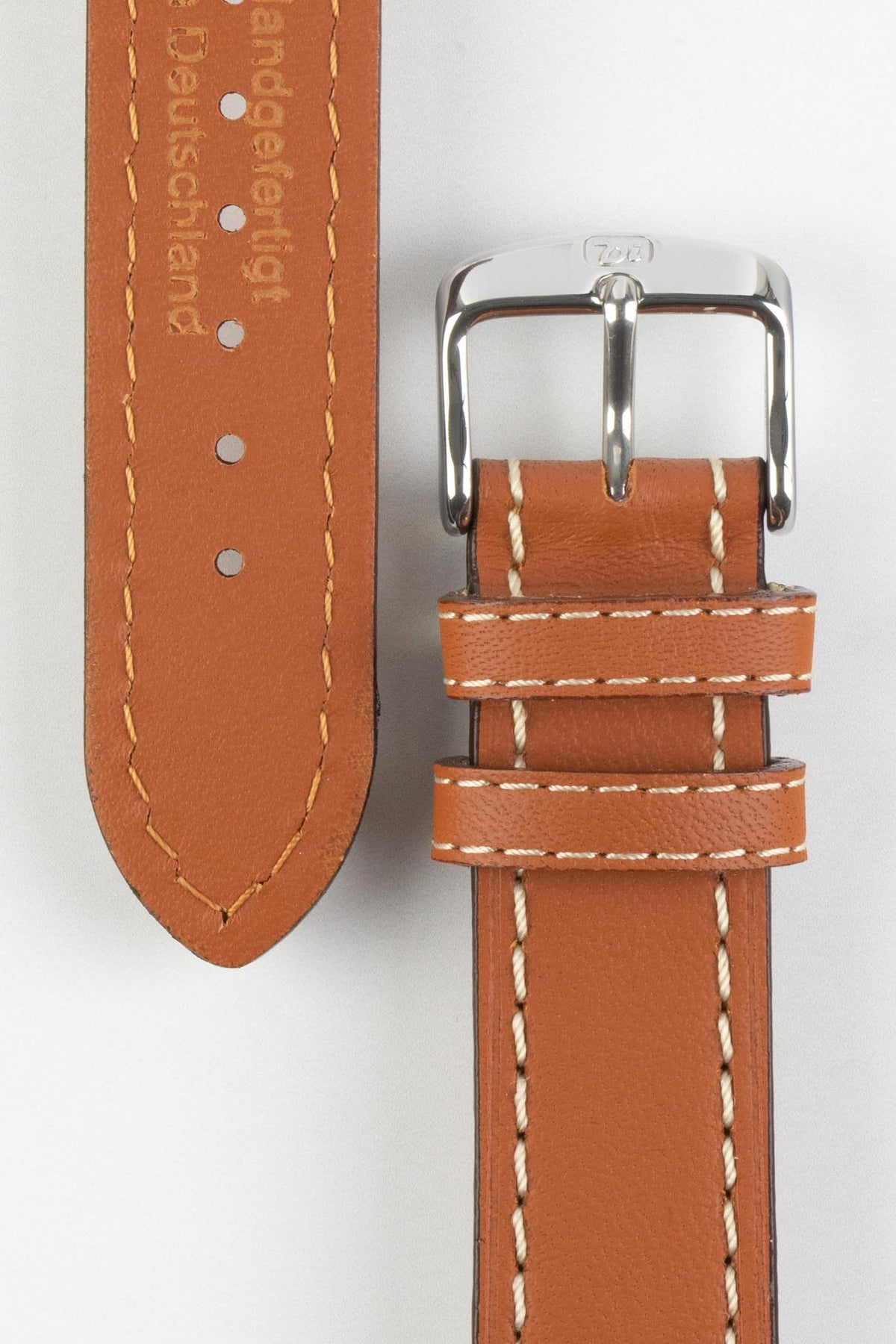 Tan vintage-style leather watch strap with cream contrast stitching, German-made leather lining, and a polished stainless steel buckle, displayed on a white background.