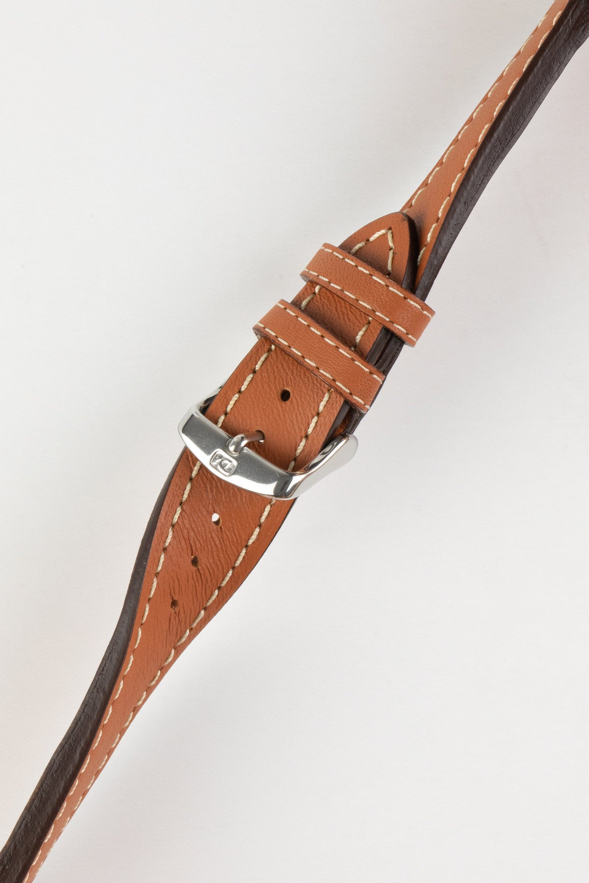 Product photograph of a tan vintage-style leather watch strap displayed on a white background. The strap features a smooth leather finish with contrasting cream stitching, matching leather keepers, multiple sizing holes, dark brown edge finishing, and a polished stainless steel pin buckle engraved with the manufacturer's logo. The image highlights the strap's tapered profile, padded construction, and classic heritage-inspired design.