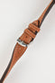 Product photograph of a tan vintage-style leather watch strap displayed on a white background. The strap features a smooth leather finish with contrasting cream stitching, matching leather keepers, multiple sizing holes, dark brown edge finishing, and a polished stainless steel pin buckle engraved with the manufacturer's logo. The image highlights the strap's tapered profile, padded construction, and classic heritage-inspired design.