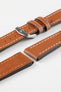 Close-up product photograph of a tan vintage-style leather watch strap displayed on a white background. The strap is shown in multiple sections, highlighting the smooth leather finish, contrasting cream stitching, polished stainless steel pin buckle, matching leather keepers, and dark brown edge finishing. The padded construction and elongated stitched channels showcase the strap's classic design, premium craftsmanship, and comfortable everyday wear.