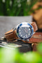 Omega Seamaster Diver 300M watch on a brown leather strap with cream contrast stitching, displayed on vintage camera equipment with a blue dial and matching blue bezel.