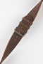 Close-up of a brown nubuck leather watch strap with a soft matte finish, tonal brown stitching, dual keeper loops, multiple adjustment holes, and a polished stainless steel buckle, displayed diagonally on a light grey background to highlight the tapered profile, vintage-inspired texture, and handcrafted leather construction.
