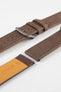 Close-up detail view of a brown nubuck leather watch strap featuring a soft matte finish, tonal brown stitching, dual keeper loops, multiple adjustment holes, a polished stainless steel buckle, and a natural tan leather lining stamped with size markings, displayed with one strap section detached on a light grey background to highlight the supple leather texture, contrasting underside, and handcrafted construction.