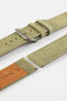 Close-up detail view of a sage green nubuck leather watch strap featuring a soft matte finish, tonal green stitching, dual keeper loops, multiple adjustment holes, a polished stainless steel buckle, and a natural tan leather lining stamped with size markings, displayed with one strap section detached on a light grey background to highlight the supple suede-like texture, contrasting underside, and premium handcrafted construction.
