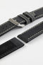 Close-up detail view of a black leather watch strap displayed with one strap section detached, featuring a smooth matte finish, contrasting cream stitching, dual keeper loops, multiple adjustment holes, a polished stainless steel buckle, and a black leather lining embossed with the Di-Modell logo and size marking, shown on a light grey background to highlight the premium handcrafted construction, tapered profile, and quick-release spring bar compatibility.