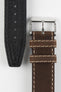 Front and back detail view of a dark brown leather watch strap featuring a smooth vintage-style finish, cream contrast stitching, dual keeper loops, a polished stainless steel buckle, and a black leather lining embossed with manufacturing details, displayed on a light grey background to highlight the premium handcrafted construction, contrasting underside, and classic heritage-inspired design.