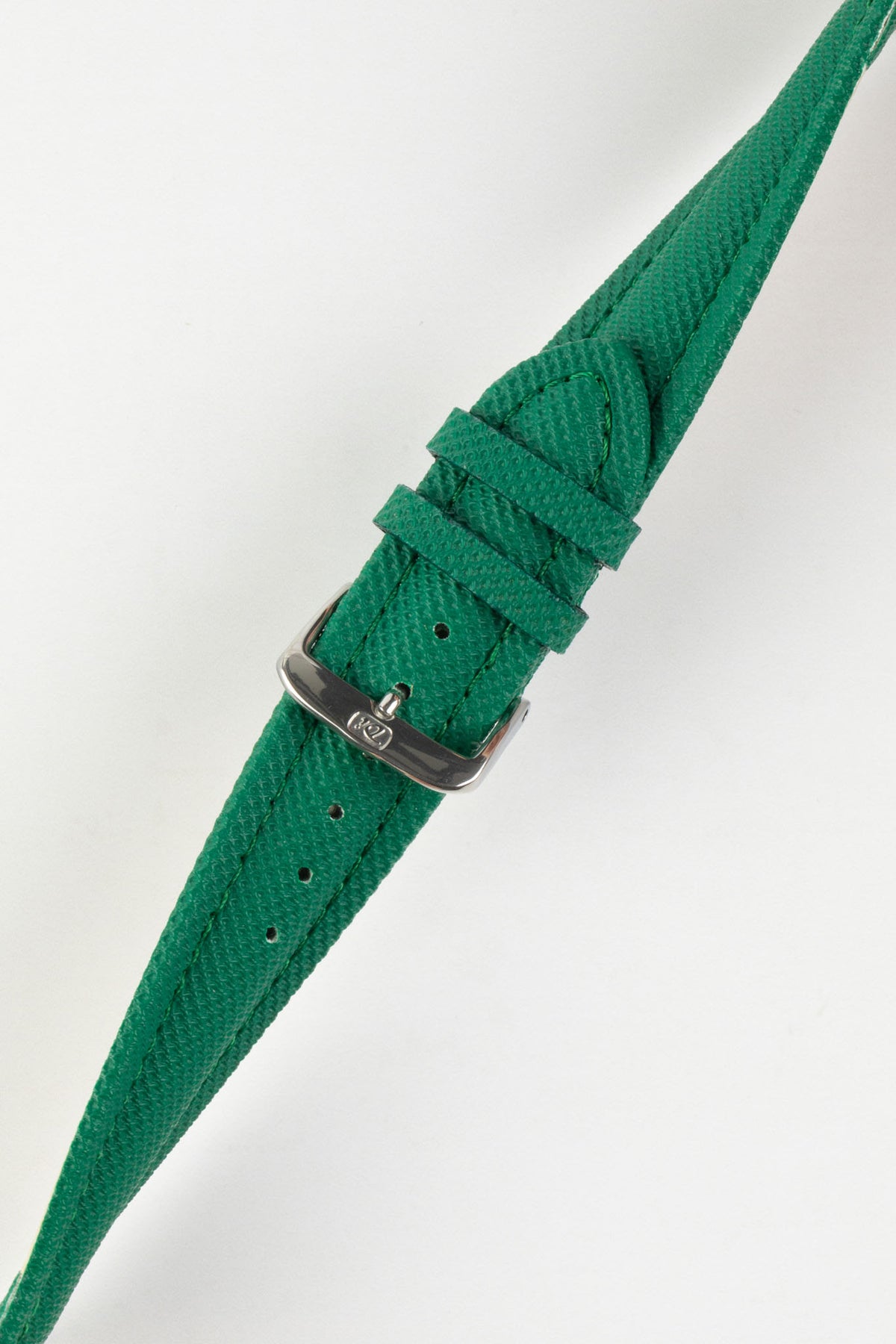 Product photograph of a green textured leather watch strap displayed on a white background. The strap features a fine embossed grain pattern, matching green stitching, two green leather keepers, multiple sizing holes, and a polished stainless steel pin buckle engraved with the manufacturer's logo. The image highlights the strap's tapered profile, premium finish, and vibrant green colour.