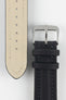 Close-up of a black Di-Modell Traveller leather watch strap on a white background, showing the textured leather finish, polished stainless steel buckle, matching black keepers, tonal stitching, beige leather-lined underside, multiple adjustment holes, and a tapered pointed tip.