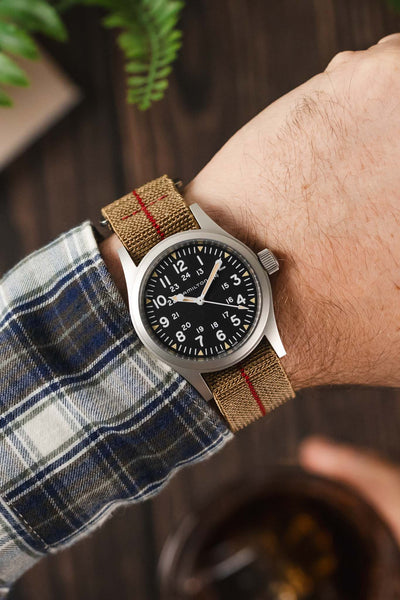 Wrist shot of Hamilton Khaki Field black dial watch fitted to an Erikas Originals Sahara strap with Red Stripe centerline