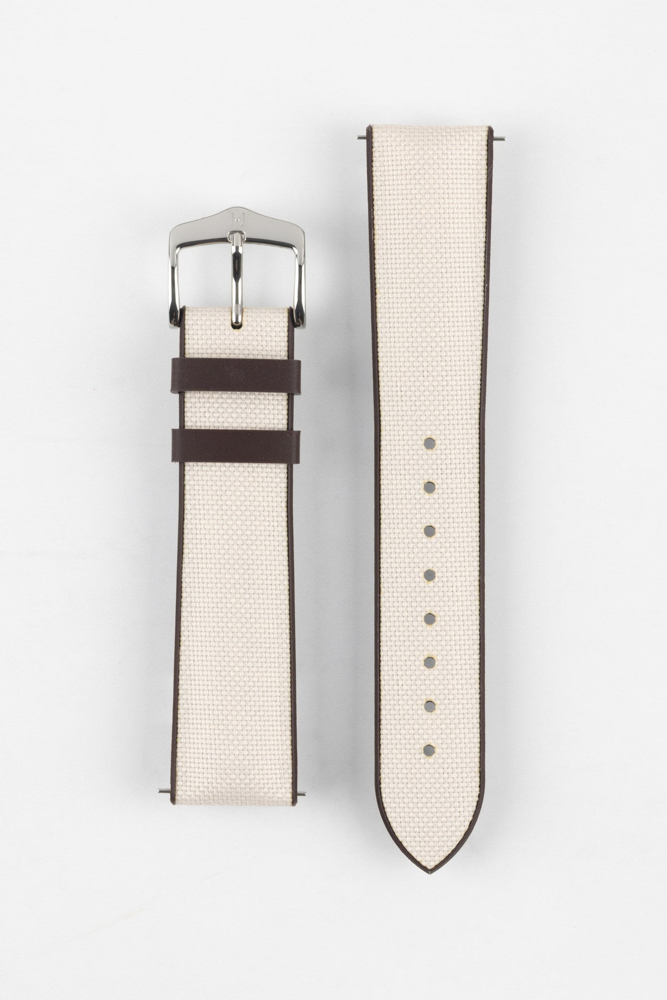 Beige textile-effect watch strap with a silver-tone buckle, displayed in two separate pieces on a white background. Features brown edges, a woven-look texture, and multiple adjustment holes.