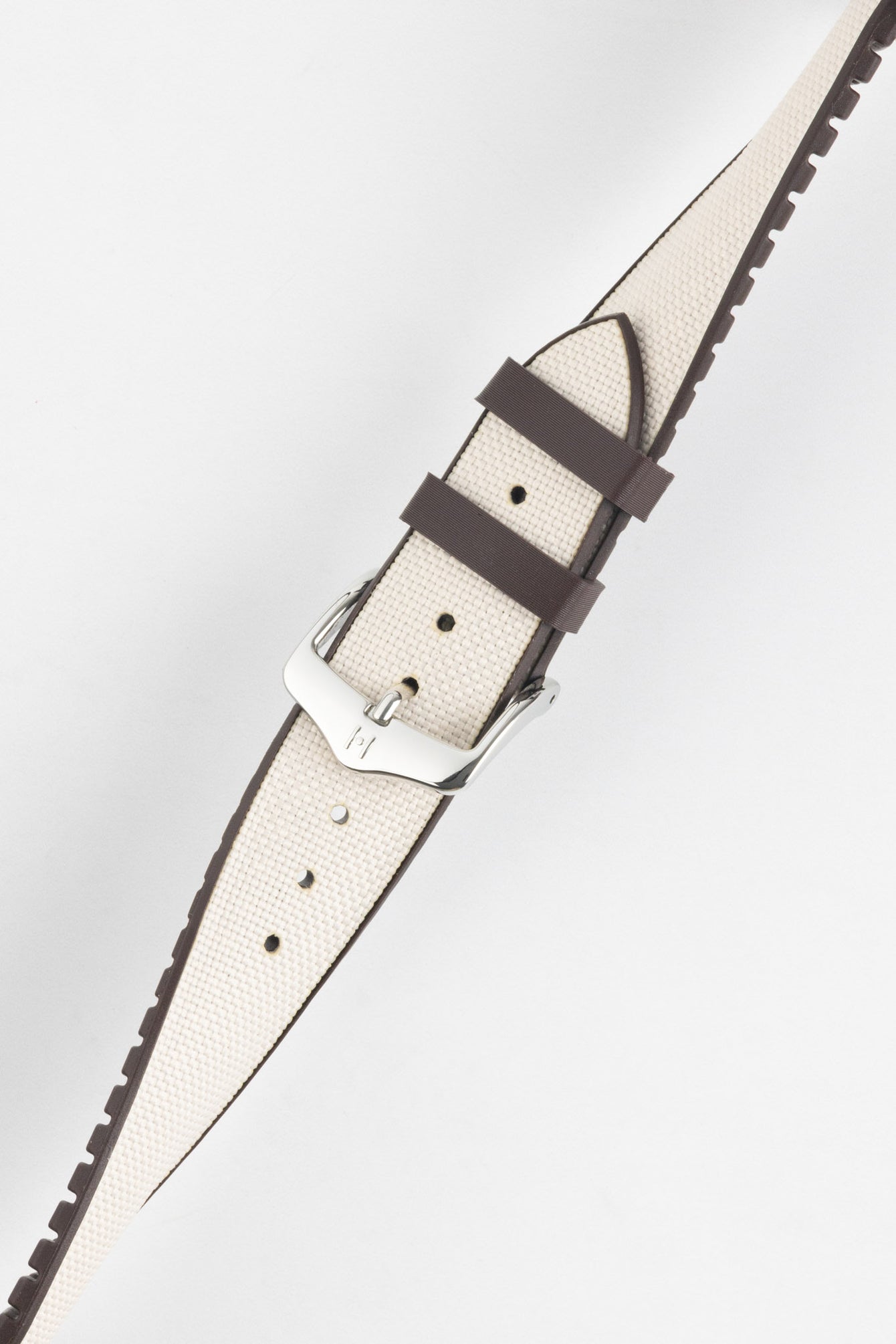 Beige textile-effect watch strap with a silver-tone buckle, shown on a white background. Features brown edges, a woven-look texture, and multiple adjustment holes.