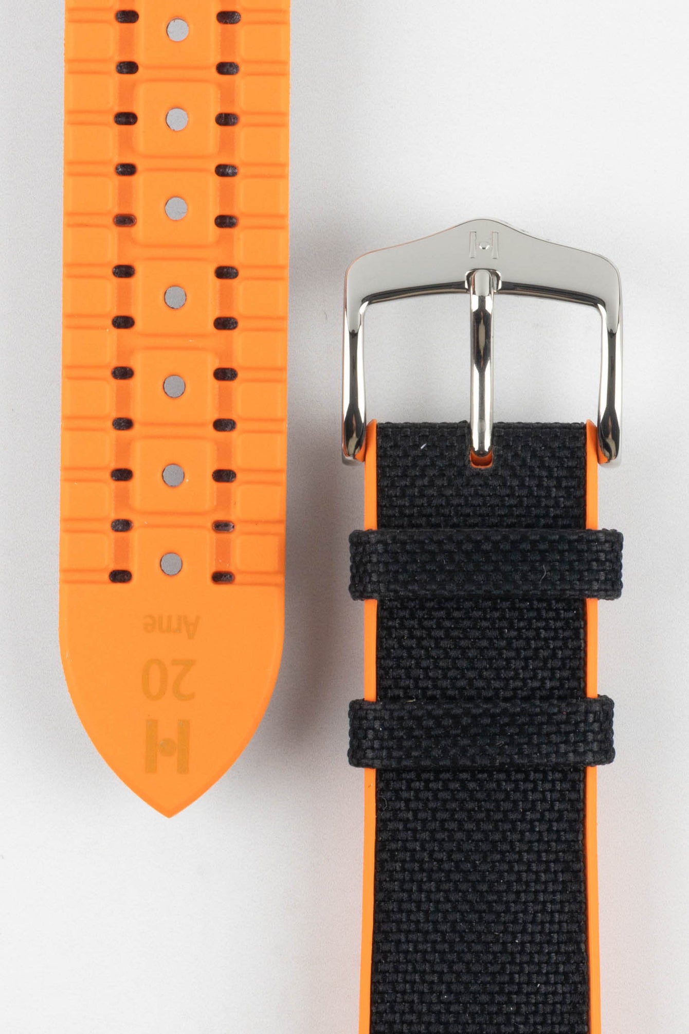 Black textile-effect watch strap with bright orange rubber backing, shown to display both the woven-look outer surface and patterned rubber underside. Features a silver-tone buckle, orange edges, and multiple adjustment holes on a white background.