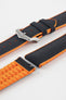 Black textile-effect watch strap with bright orange rubber backing and a brushed silver-tone buckle, shown in separate sections on a white background. Features a textured woven-look surface, orange edges, and a patterned rubber underside.