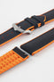 Black textile-effect watch strap with bright orange rubber backing and a silver-tone buckle, shown in separate sections on a white background. Features a textured woven-look surface, orange edges, and a patterned rubber underside.
